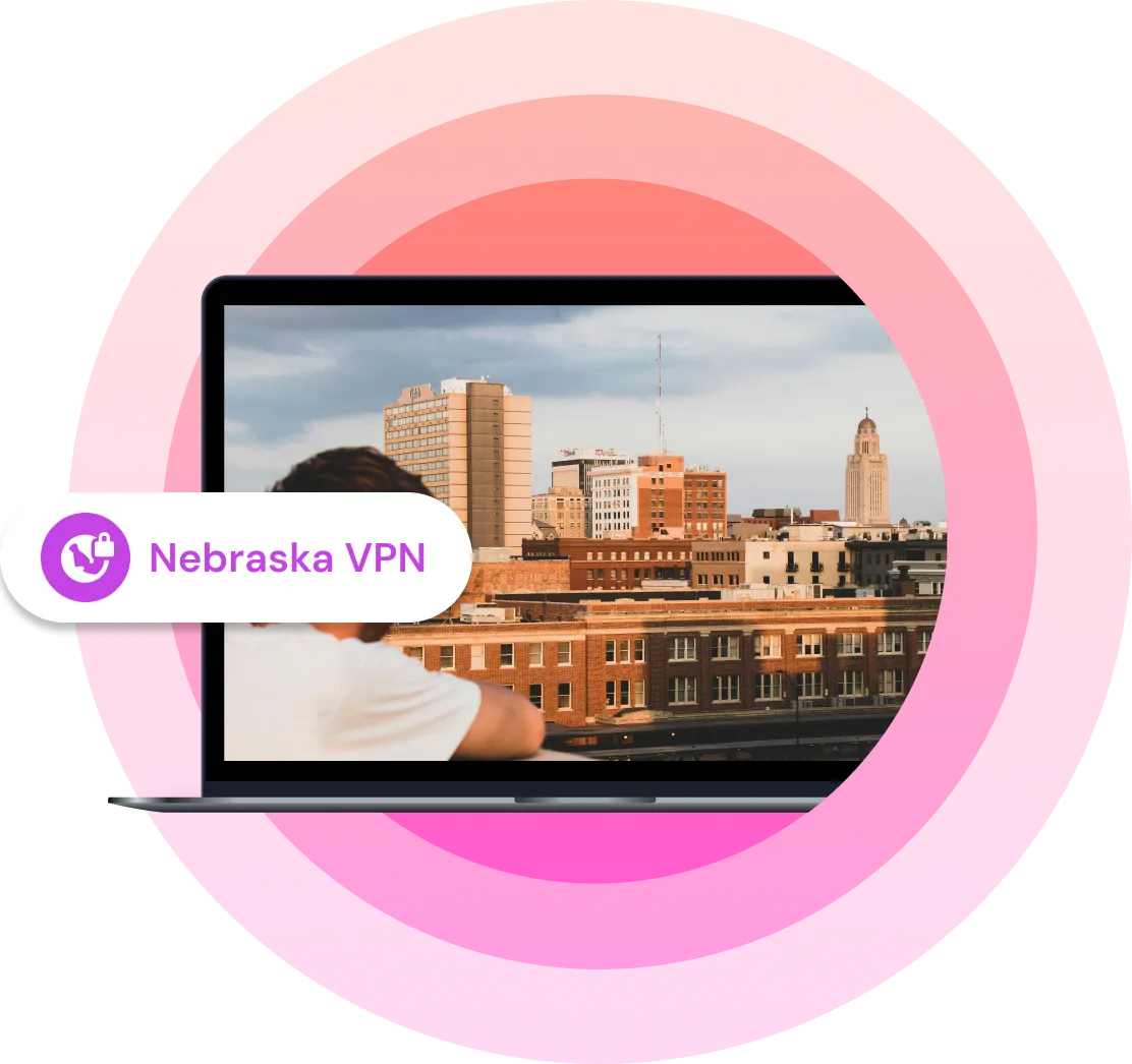 Laptop with an image of a man standing on a balcony in a city in Nebraska during sunset